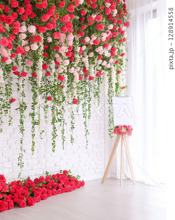 Glamorous floral wall decor with a blank poster stand and vibrant flower arrangements 128914558