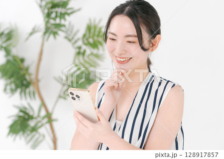 スマホを見る女性 128917857
