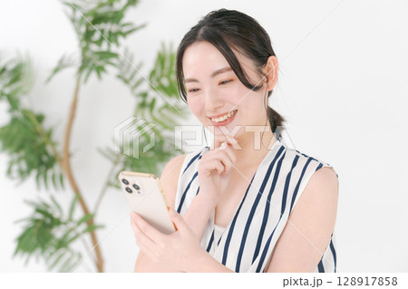 スマホを見る女性 128917858