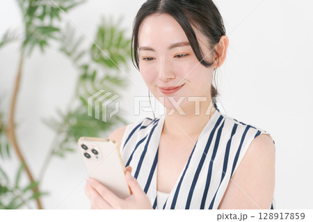 スマホを見る女性 128917859