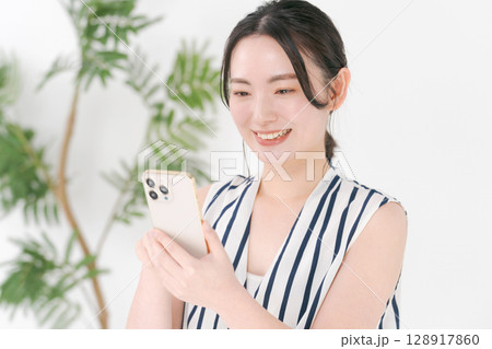 スマホを見る女性 128917860