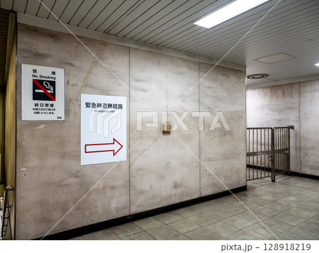 地下の鉄道駅構内に掲示された緊急時避難経路の案内表示 128918219