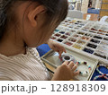 天然石アクセサリーでブレスレットを作る女の子 128918309