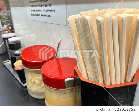 ラーメン屋のカウンター席　割りばしと調味料 128918855