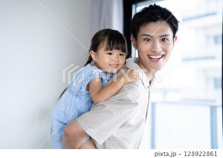 娘をおんぶしている父親 娘をおんぶしている父親 128922861