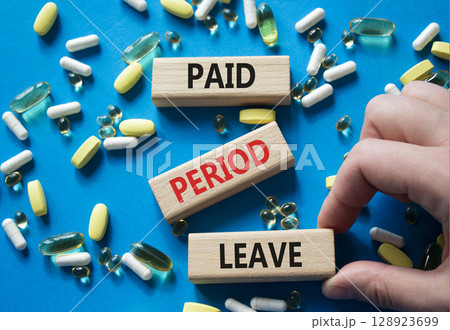 Paid Period Leave symbol. Concept words Paid Period Leave on wooden blocks. Beautiful blue background with pills. Doctor hand. Healthcare and Paid Period Leave concept. Copy space. 128923699