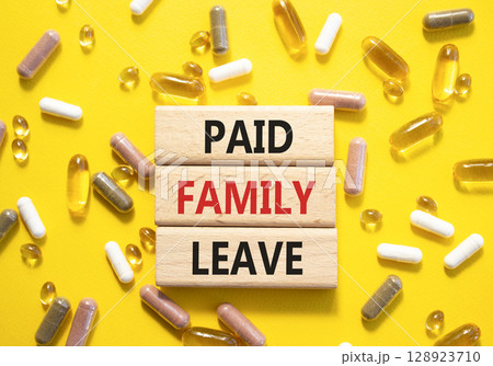Paid Family Leave symbol. Concept words Paid Family Leave on wooden blocks. Beautiful yellow background with pills. Healthcare and Paid Family Leave concept. Copy space. 128923710