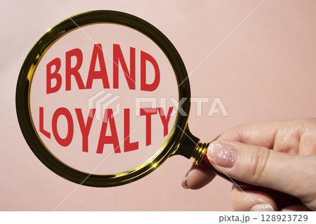Brand Loyalty symbol. Concept word Brand Loyalty on magnifying glass. Beautiful pink background. Businessman hand. Business and Brand Loyalty concept. Copy space. Brand Loyalty symbol. Concept word Brand Loyalty on magnifying glass. Beautiful pink background. Businessman hand. Business and Brand Loyalty concept. Copy space. 128923729
