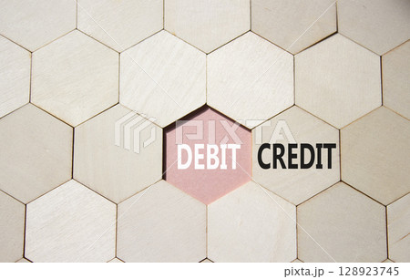 Debit or Credit symbol. Concept word Debit or Credit on wooden comb puzzle. Beautiful pink background. Business and Debit or Credit concept. Copy space 128923745