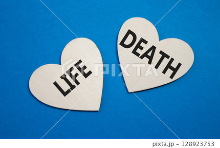 Life or Death symbol. Concept word Life or Death on wooden hearts. Beautiful blue background. Business and Life or Death concept. Copy space 128923753