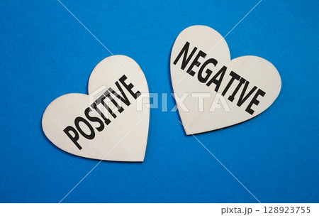 Positive or Negative symbol. Concept word Positive or Negative on wooden hearts. Beautiful blue background. Business and Positive or Negative concept. Copy space 128923755