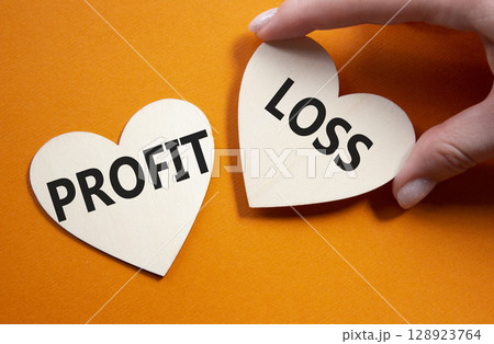 Profit or Loss symbol. Concept word Profit or Loss on wooden hearts. Businessman hand. Beautiful orange background. Business and Profit or Loss concept. Copy space 128923764