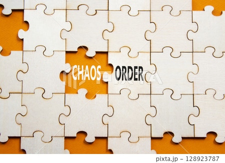 Chaos or Order symbol. Concept word Chaos or Order on wooden puzzle. Beautiful orange background. Business and Chaos or Order concept. Copy space 128923787