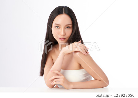A beautiful young Asian woman with clean, fresh skin against a white background. Skincare, facial treatment, cosmetology, beauty, and spa. An elegant portrait of an Asian woman. 128925050