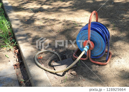 公園にある青い散水ホース 公園にある青い散水ホース 128925664