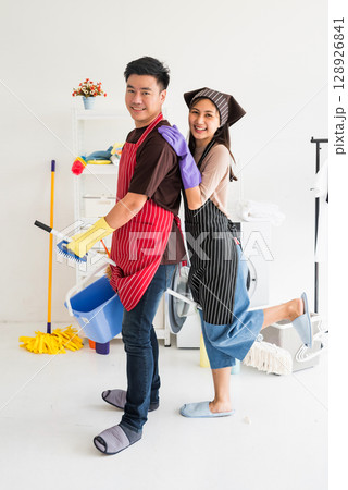 happy Asian young couple together holding house clean equipments 128926841