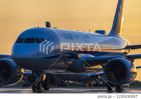 朝日で輝く旅客機 128926897