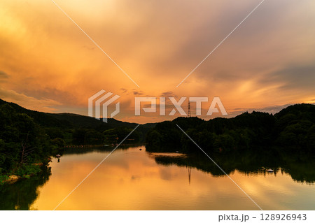 2025年夏　布目湖上空を覆う空一面の夕焼けと湖面のリフレクション① 128926943