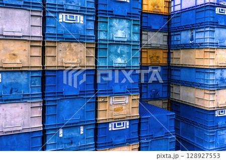 Stack of colorful plastic industrial crates arranged in a grid pattern for storage or transport use Stack of colorful plastic industrial crates arranged in a grid pattern for storage or transport use 128927553