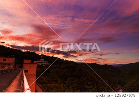 2025年夏　奈良布目ダムの西の空を覆う茜雲　茜色に染まる堰堤と夕焼け空① 128927679
