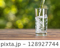 Drink water pouring into glass on wooden table 128927744