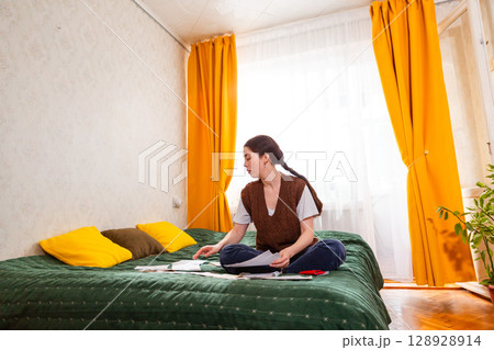 Female structuring home budget balancing expenses and researching investment options. concept of economy and financial independence. Copy space Female structuring home budget balancing expenses and researching investment options. concept of economy and financial independence. Copy space 128928914