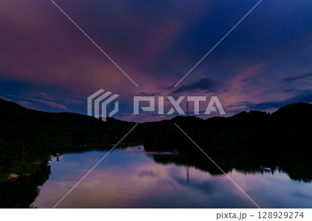 2025年夏奈良布目ダムの美しい夕焼け　ブルーモーメントの空に浮かぶ夕焼け雲　布目湖上空の空① 128929274