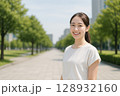 都会の緑道で微笑む日本人女性 128932160