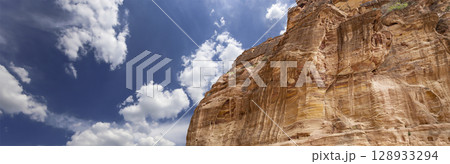 Mountains of Petra (against the background of a beautiful sky with clouds), Jordan, Middle East. Petra has been a UNESCO World Heritage Site since 1985 128933294