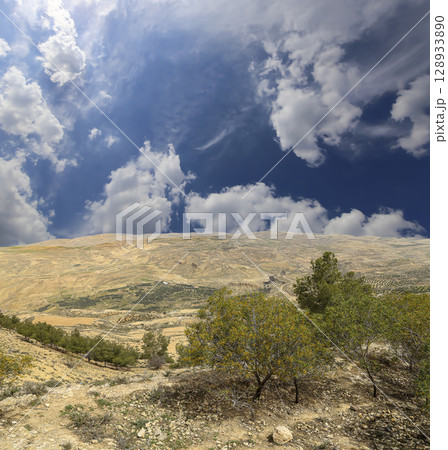 Typical mountain landscape, Jordan, Middle East (photography from a high point). Against the background of a beautiful sky with clouds Typical mountain landscape, Jordan, Middle East (photography from a high point). Against the background of a beautiful sky with clouds 128933890