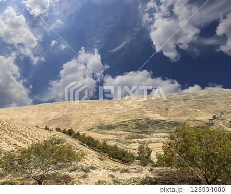 Typical mountain landscape, Jordan, Middle East (photography from a high point). Against the background of a beautiful sky with clouds Typical mountain landscape, Jordan, Middle East (photography from a high point). Against the background of a beautiful sky with clouds 128934000