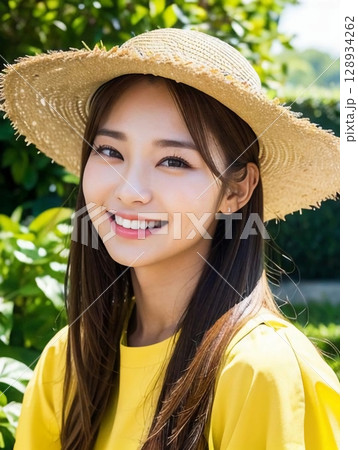 麦わら帽子をかぶった女性 128934262