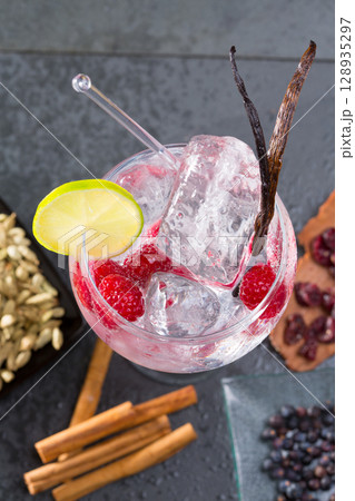 Gin tonic cocktail with vanilla raspberry lima slice and ice Gin tonic cocktail with vanilla raspberry lima slice and ice 128935297