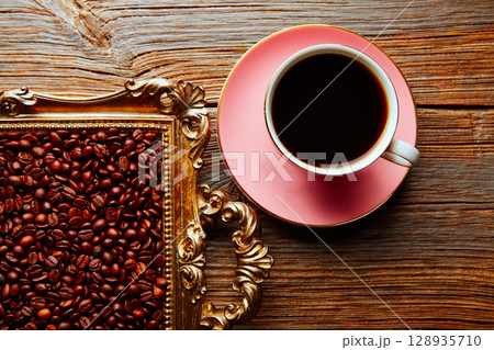 Coffee cup and beans on vintage golden tray Coffee cup and beans on vintage golden tray 128935710
