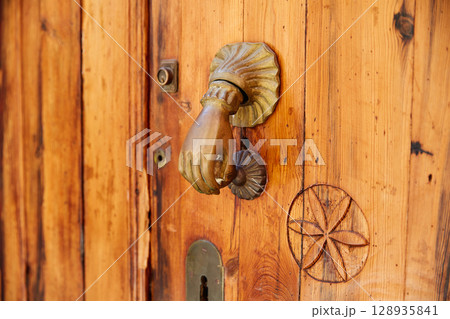 Door brass knock hand shape in Spain Door brass knock hand shape in Spain 128935841