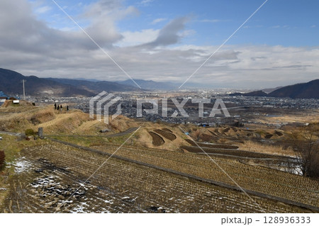 晴れ間が出た正月2日、雪の残る長野県姨捨(おばすて)の棚田から川中島、善光寺平を見渡す 128936333