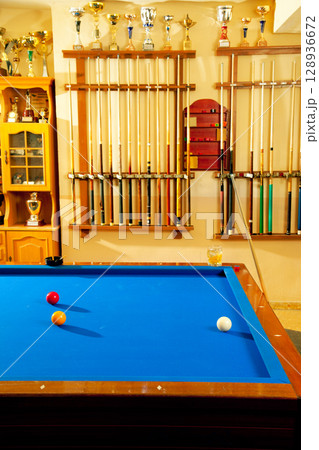 Billiard club with blue pool table cue and trophy 128936672