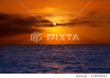 golden sunrise with sun and clouds over sea 128936681