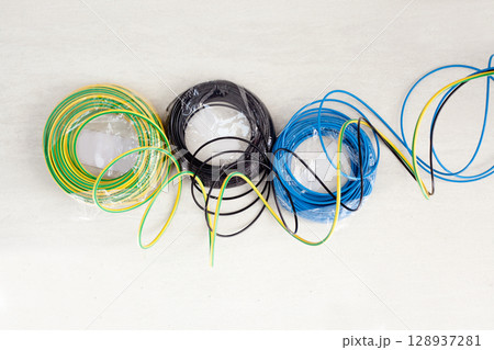 Electric cable coil in three colors black blue and earth 128937281
