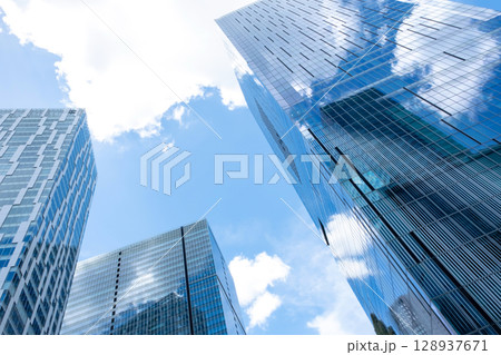高層ビルを見上げるオフィス街の風景 128937671
