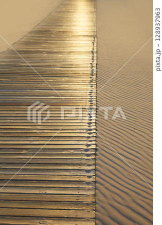 Beach wooden walkway and sand dunes texture Beach wooden walkway and sand dunes texture 128937963