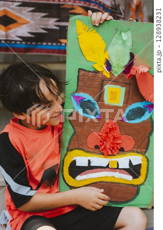 Boy Proudly Displays Colorful Handmade Mask 128938231