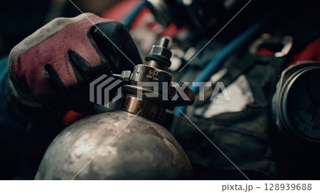 First-Person View of Hands Adjusting Oxygen Tank Valve in Hazardous Zone Gear Close-Up First-Person View of Hands Adjusting Oxygen Tank Valve in Hazardous Zone Gear Close-Up 128939688