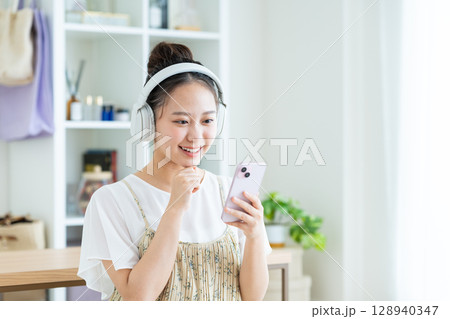 家で音楽を聴く若い女性 128940347