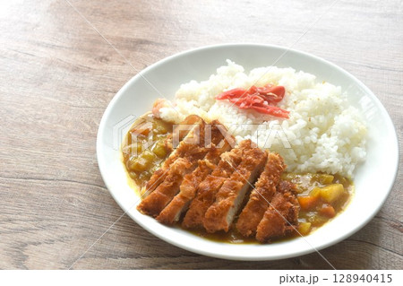 Tonkatsu crispy fried pork slice topping plain rice dressing potato and carrot in Japanese curry on plate  128940415