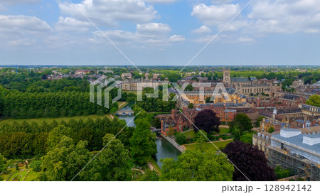 Cambridge University buildings and River Cam flowing through green park in a sunny summer day 128942142