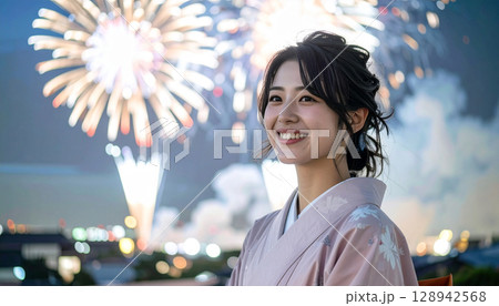 夏の夜空に咲く花火と浴衣姿の女性の笑顔 128942568