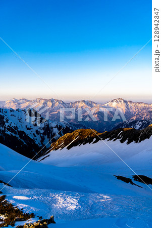 夕日に染まる後立山連峰の稜線(剱御前からの景色) 残雪期の北アルプス立山・別山登山 夕日に染まる後立山連峰の稜線(剱御前からの景色) 残雪期の北アルプス立山・別山登山 128942847