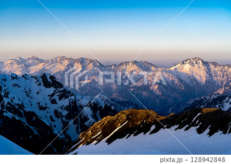 夕日に染まる後立山連峰の稜線（剱御前からの景色）　残雪期の北アルプス立山・別山登山 128942848
