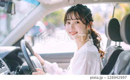 ドライブ中の笑顔が爽やかな若い女性の旅のワンシーン 128942997